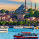 Istanbul skyline at sunset with Suleymaniye Mosque, Golden Horn waterway, and passenger ferries